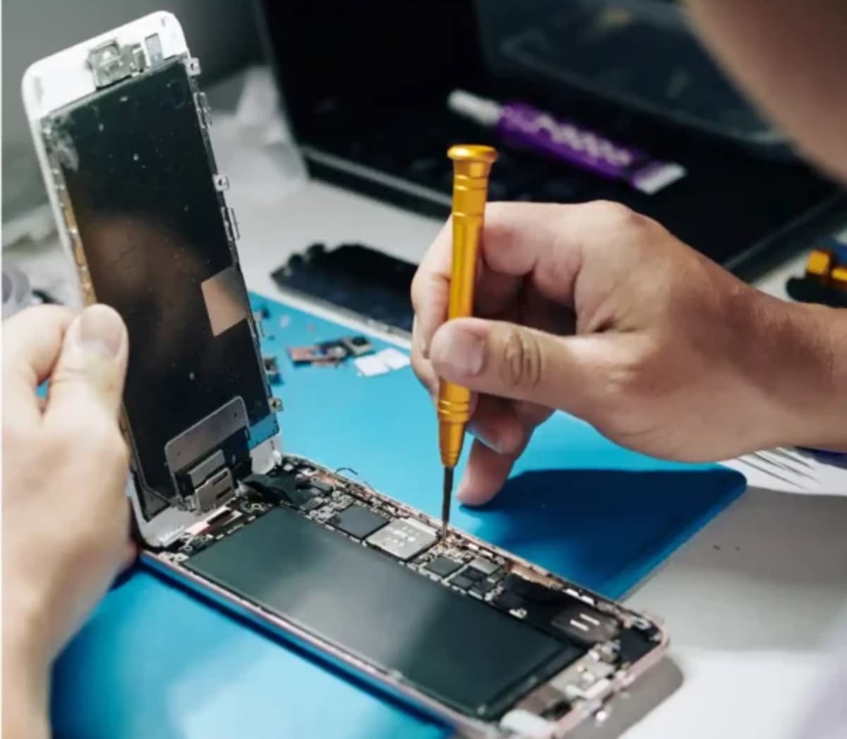 Technician performing detailed phone repair with professional tools